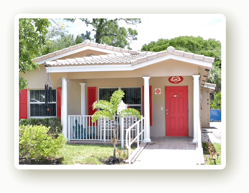 The House of Love and Gratitude — a house with red doors and white porch rails