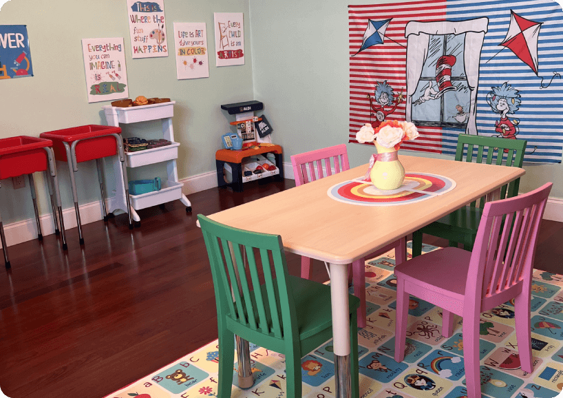 A table and chairs in a room with toys on the floor
